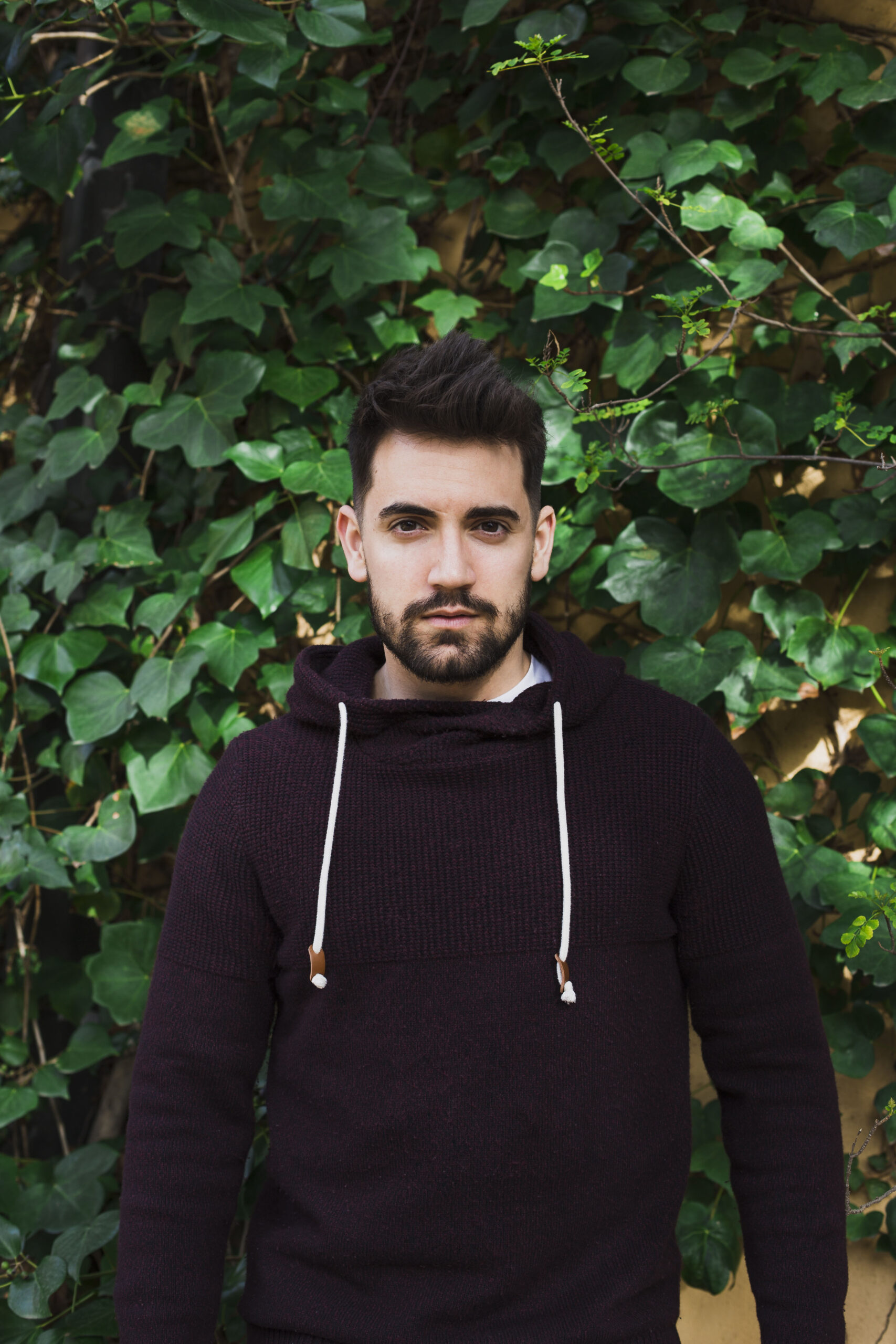 man standing near green leaves